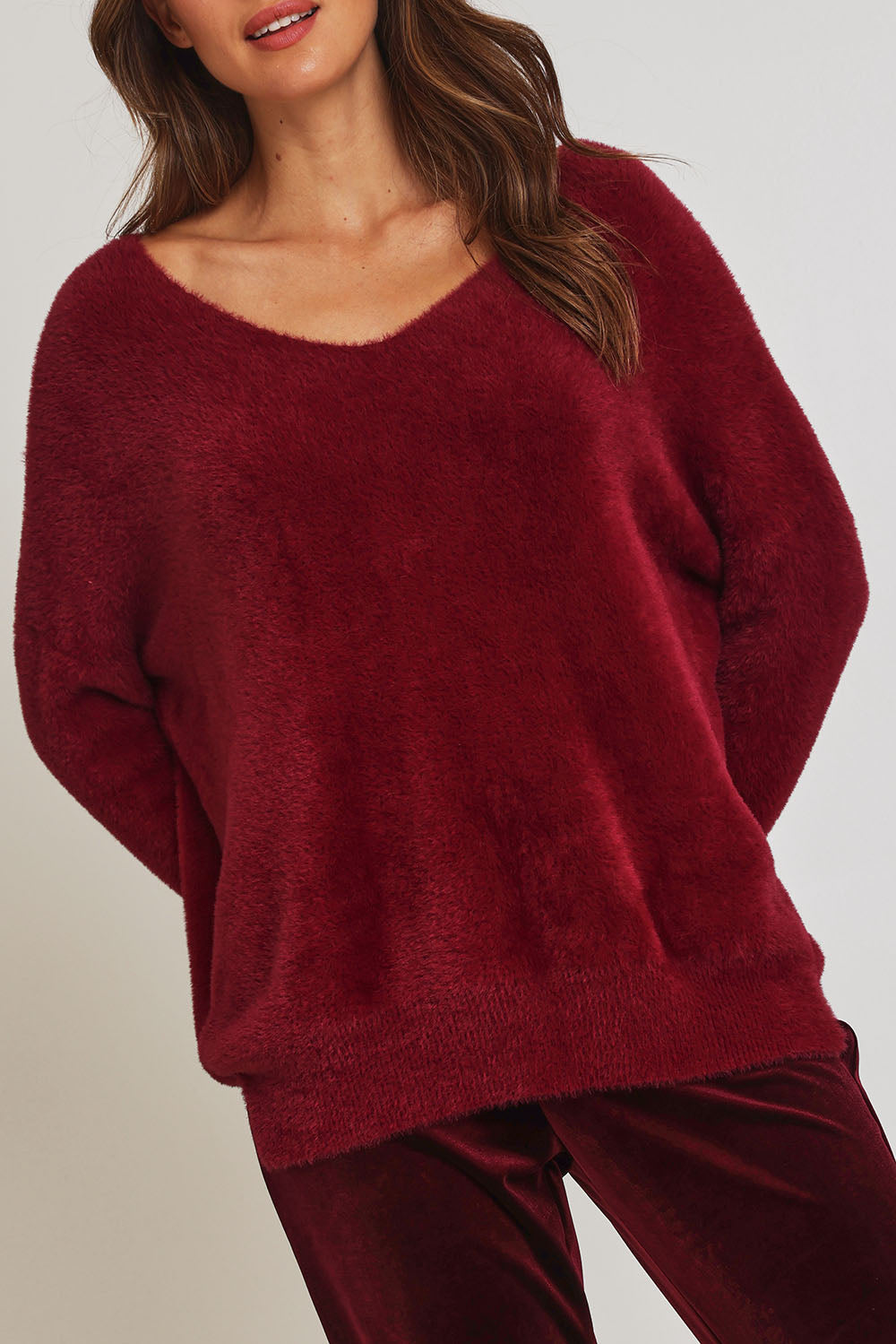Model Madeline wearing size 10 of the Electra Knit in colour Wine (Red), from the front, cropped image