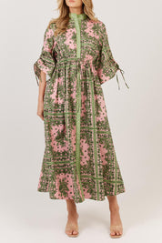 A model wearing the Dominica Cotton Dress in colour Paisley (Green), from the front, cropped image