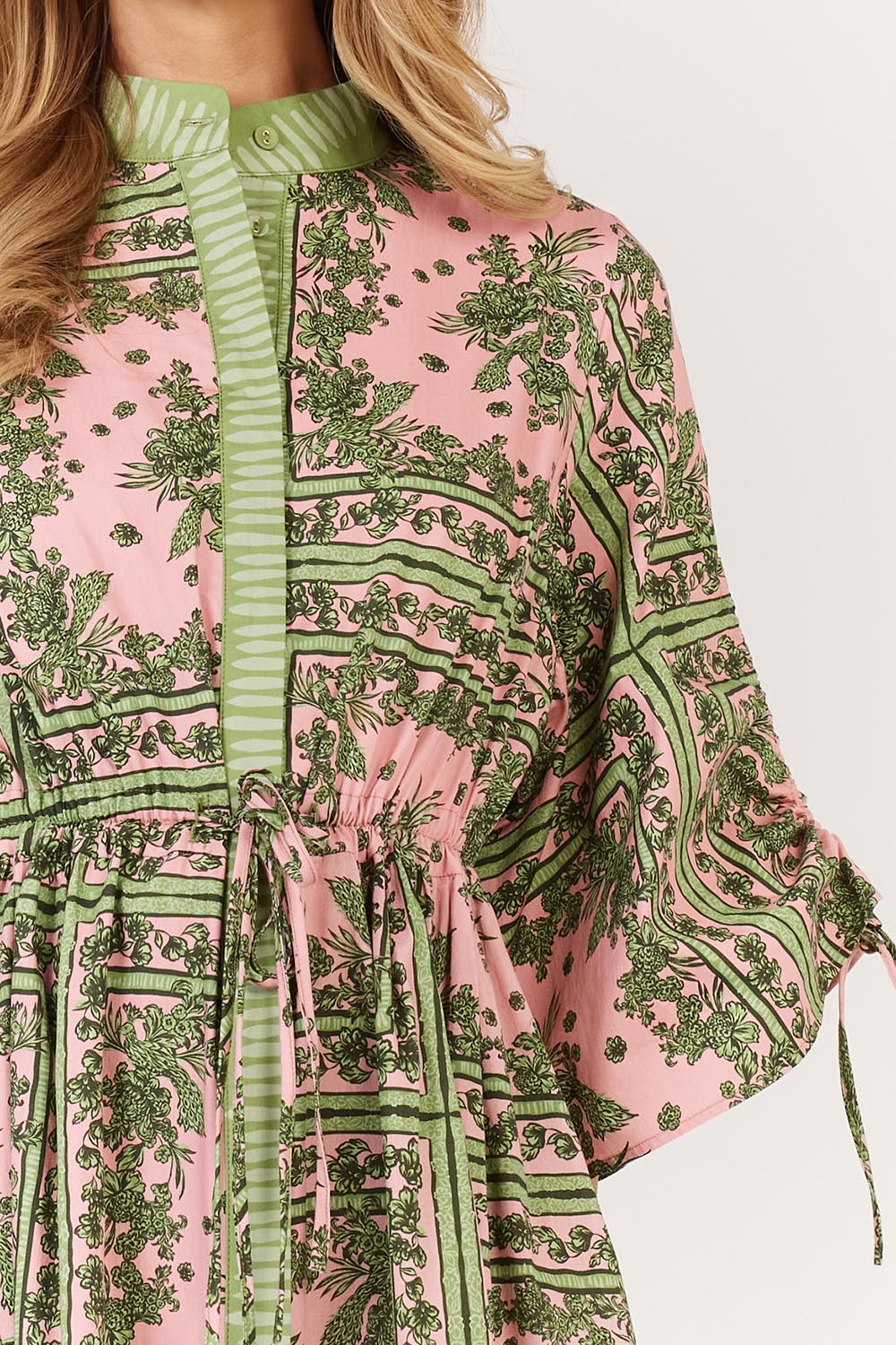 A model wearing the Dominica Cotton Dress in colour Paisley (Green), from the front, cropped image
