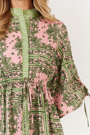 A model wearing the Dominica Cotton Dress in colour Paisley (Green), from the front, cropped image