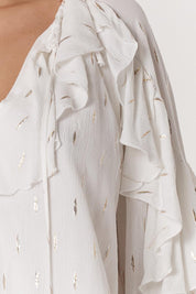 A model wearing the Delia Ruffle Top in colour White (White), from the front, cropped image