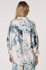 A model wearing the Solstice Palms Shirt in colour Palm (Blue), from the back
