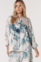 A model wearing the Solstice Palms Shirt in colour Palm (Blue), from the front, cropped image