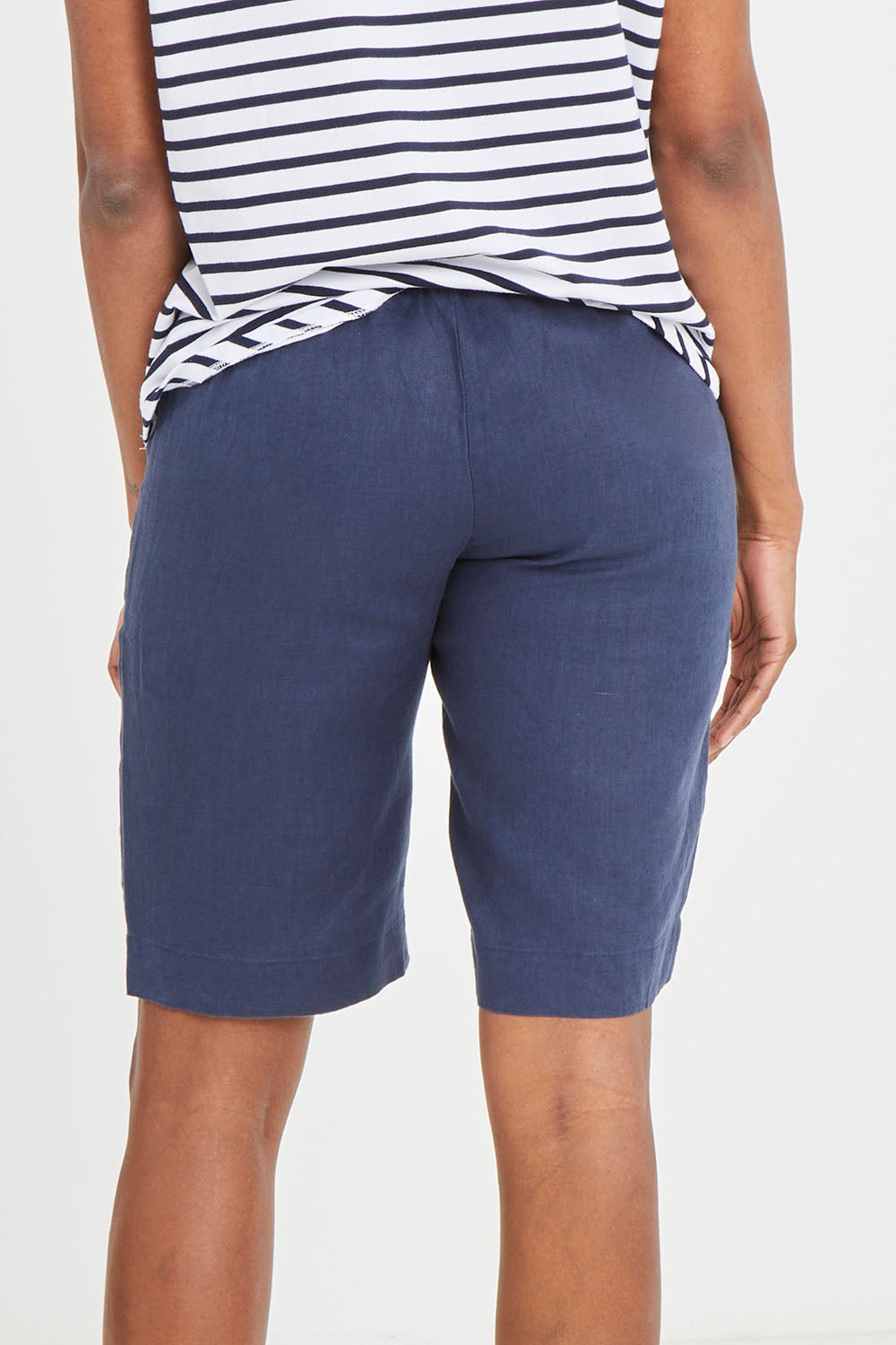 Model Aiyana wearing size 10 of the Pull On Linen Short in colour Marine (Blue), from the back