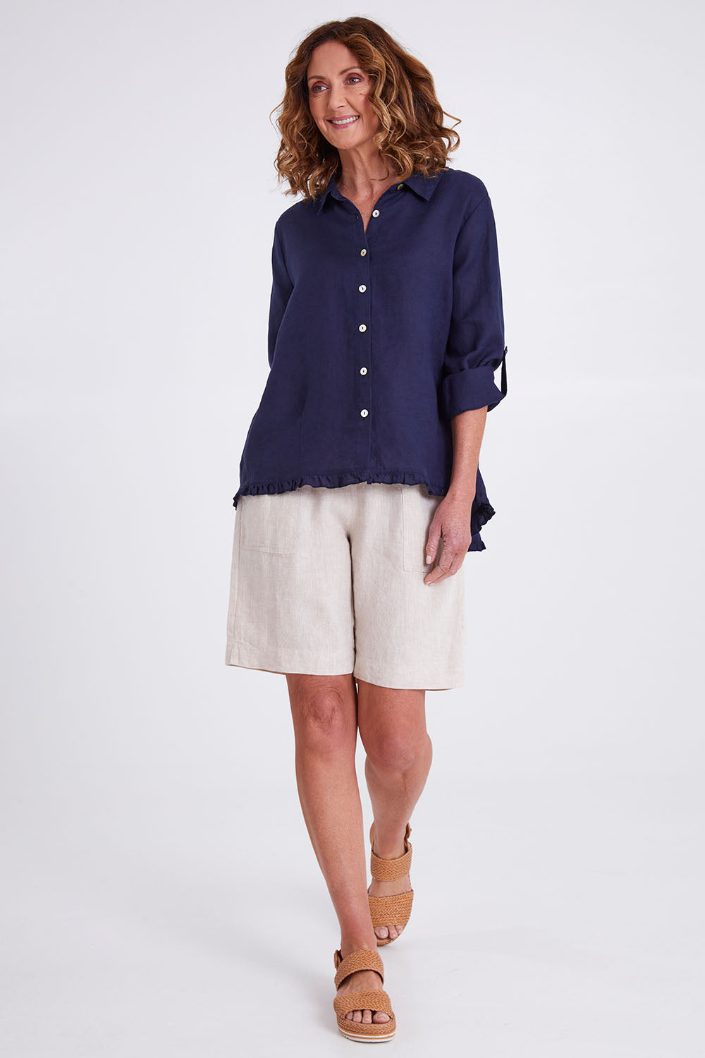 Model Emma wearing size 10 of the Ruffle Hem Linen Shirt in colour Navy (Blue), from the front, showing the whole outfit