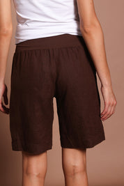 Model Madeline wearing size 10 of the Jersey Waist Linen Short in colour Koko, from the back
