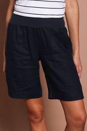 Model Madeline wearing size 10 of the Jersey Waist Linen Short in colour Navy (Blue), from the front, cropped image