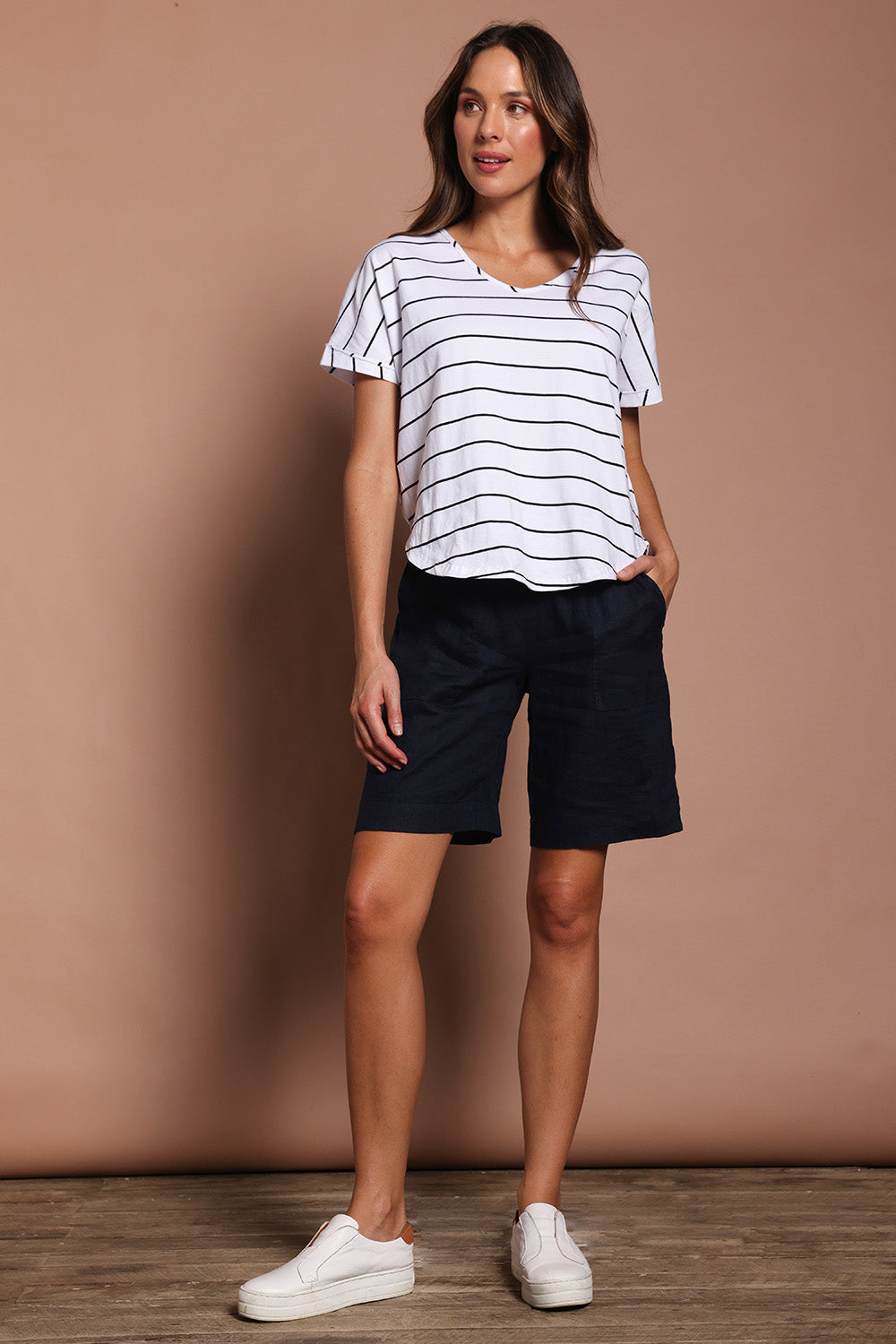 Model Madeline wearing size 10 of the Jersey Waist Linen Short in colour Navy (Blue), from the front, showing the whole outfit