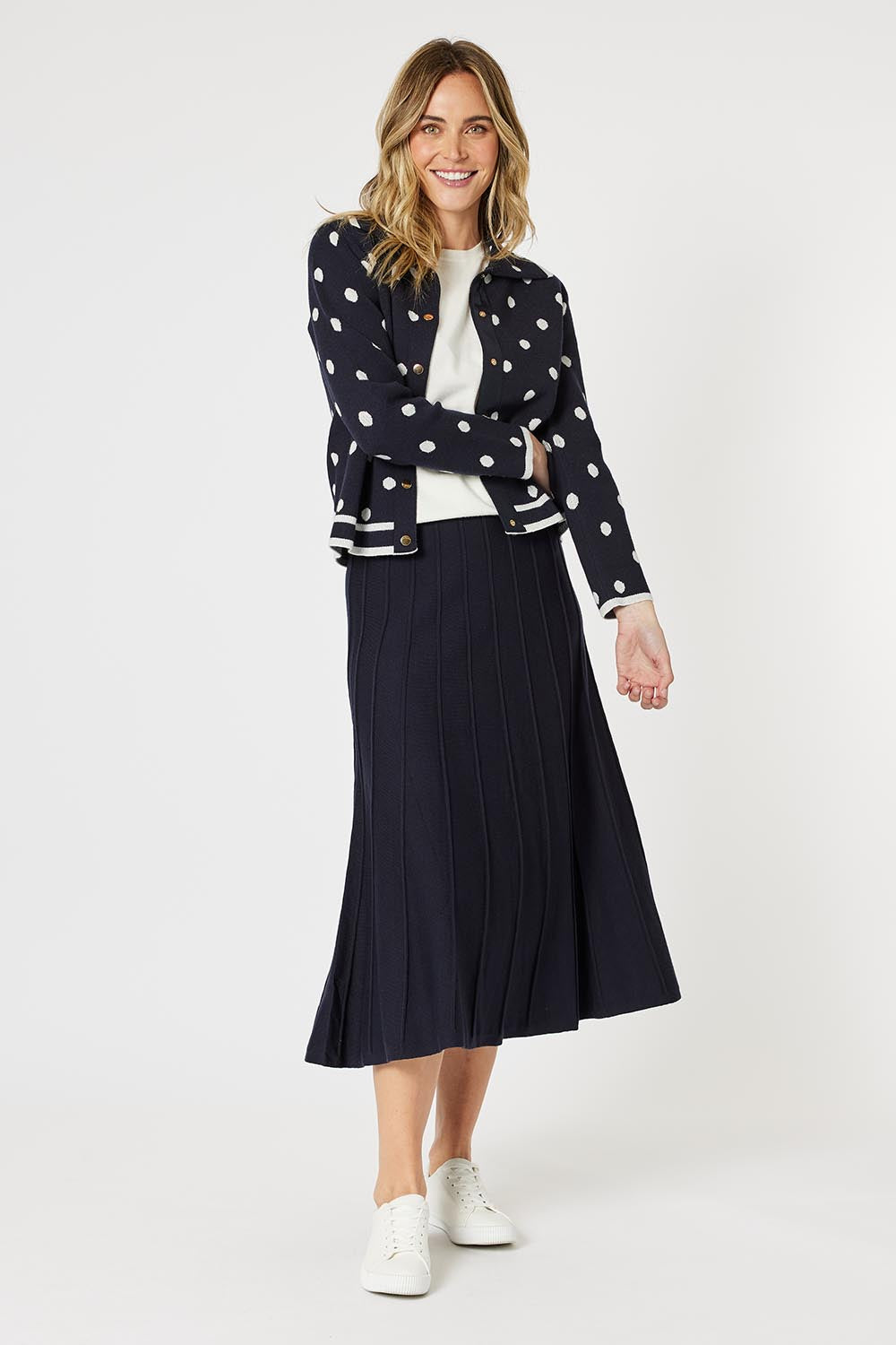 A model wearing the Kate Knit Long Skirt in colour Navy (Blue), from the front, showing the whole outfit