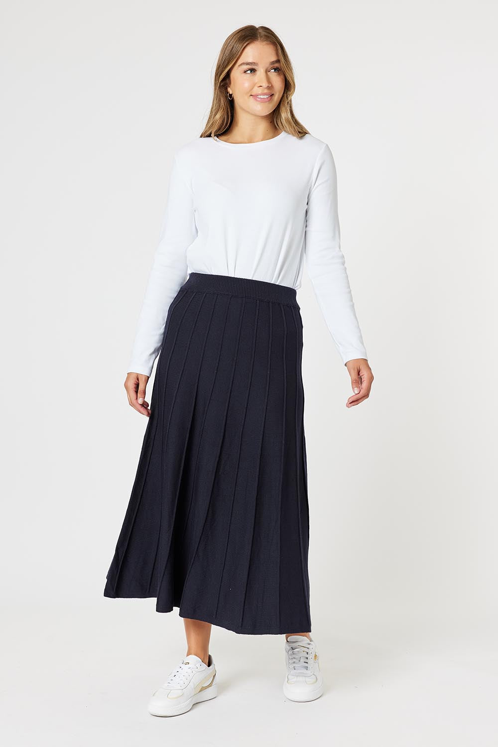 A model wearing the Kate Knit Long Skirt in colour Navy (Blue), from the front, showing the whole outfit