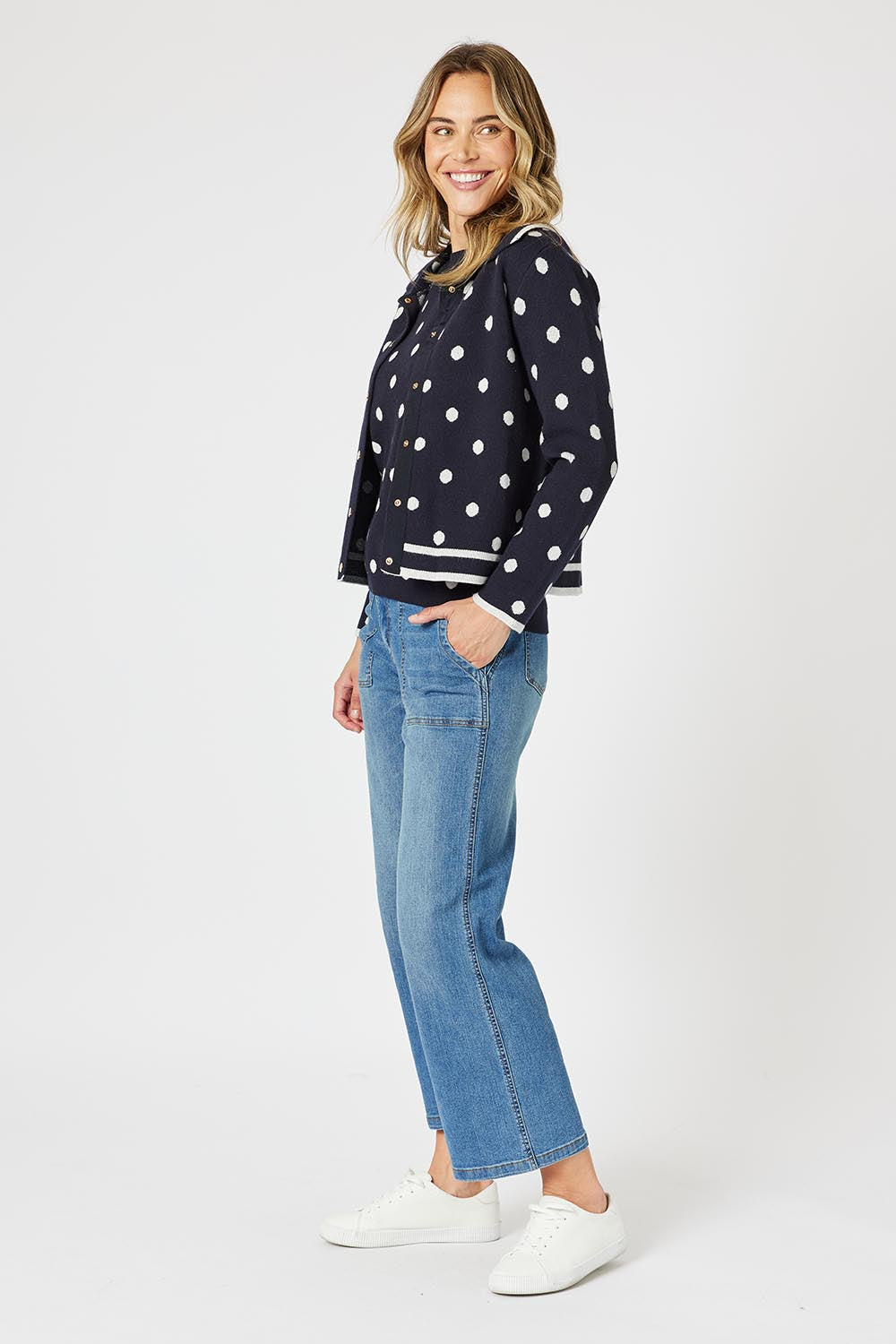 A model wearing the Ascot Cardigan in colour Navy (Blue), from the front, showing the whole outfit