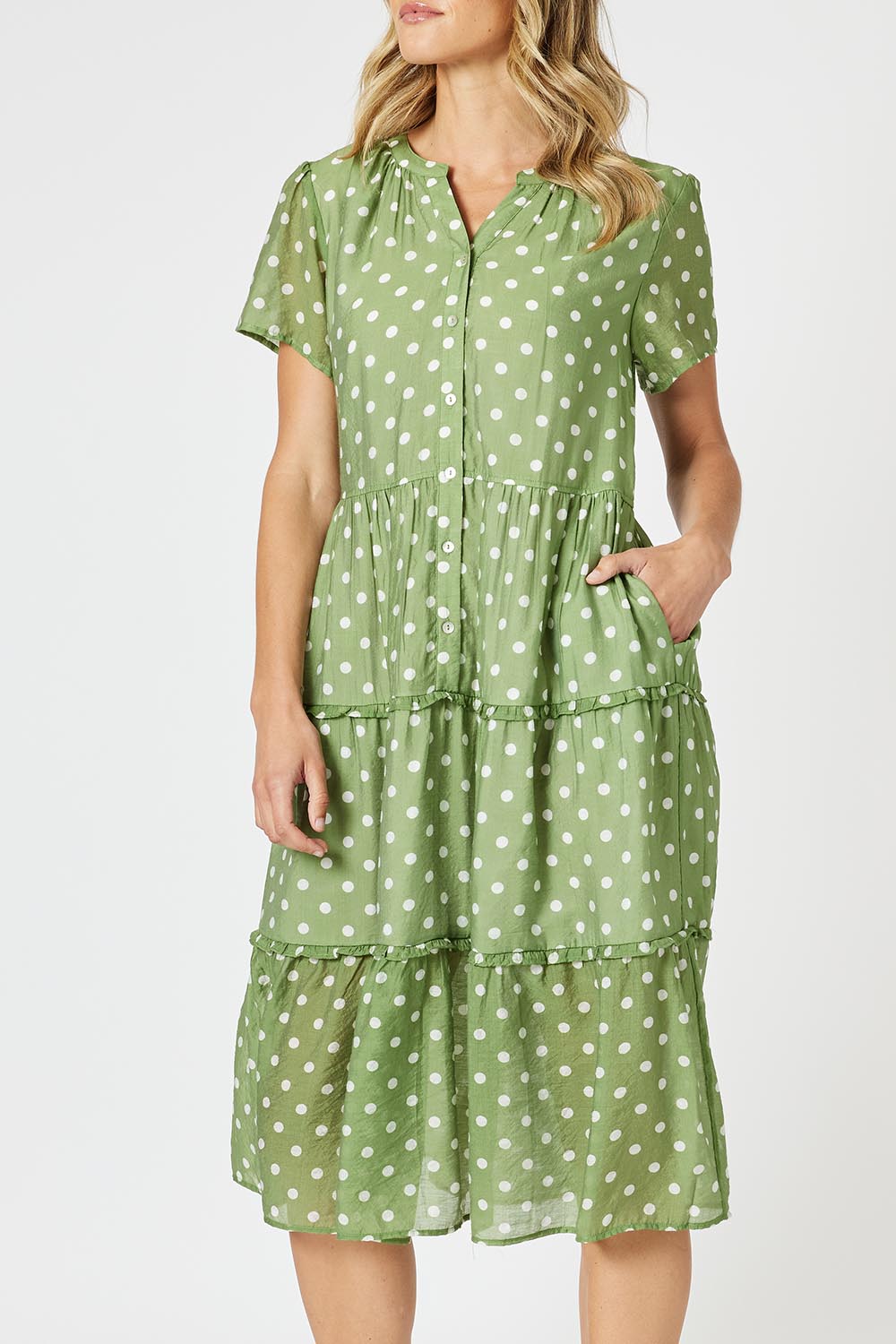 A model wearing the Basil Spot Dress in colour Basil (Green), from the front, cropped image
