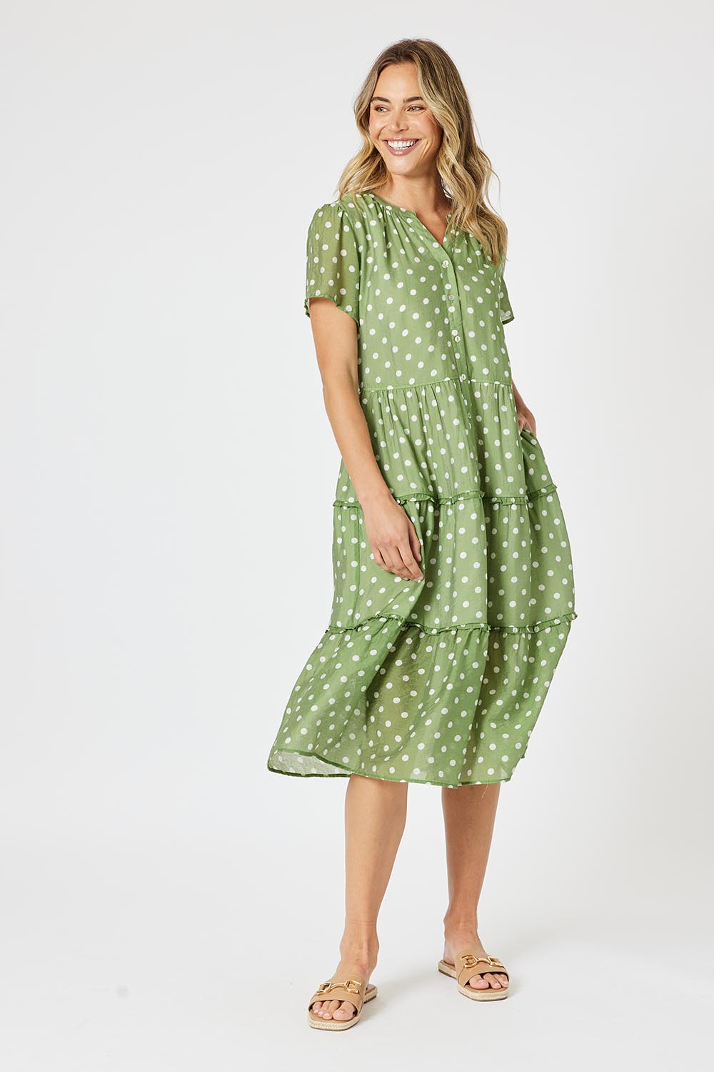 A model wearing the Basil Spot Dress in colour Basil (Green), from the front, showing the whole outfit
