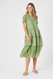 A model wearing the Basil Spot Dress in colour Basil (Green), from the front, showing the whole outfit