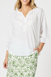 A model wearing the Coastal Embroidered Cotton Top in colour White (White), from the front, cropped image