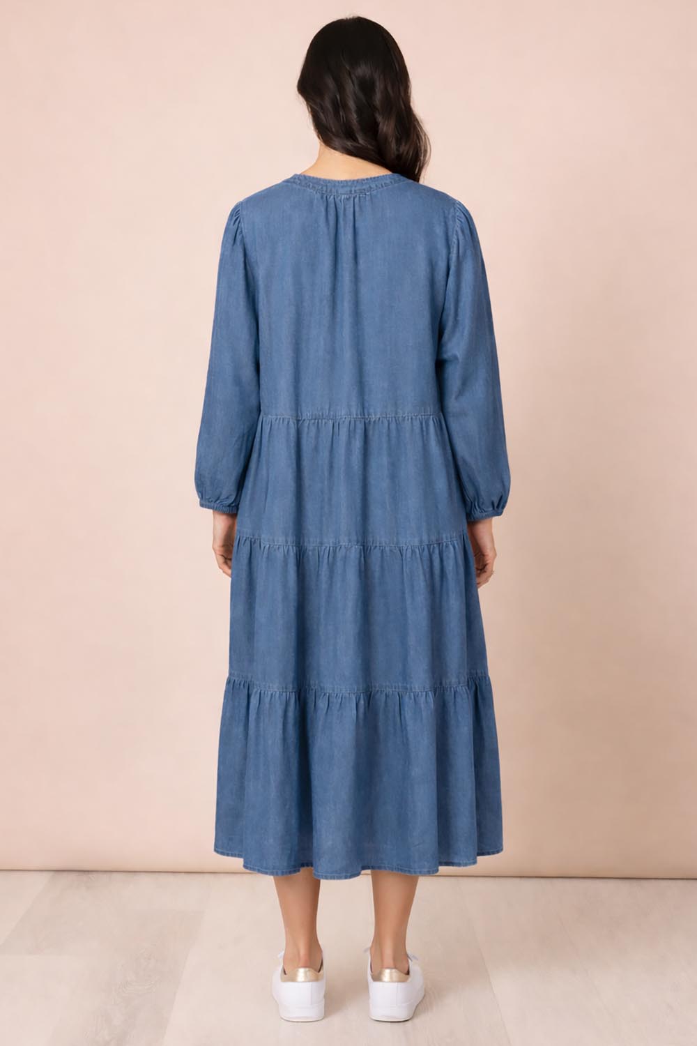 A model wearing the Macy Lyocell Dress in colour Denim (Blue), from the back