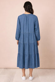 A model wearing the Macy Lyocell Dress in colour Denim (Blue), from the back