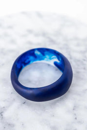 A model wearing the Resin Stacking Cuff Bangle in colour Cobalt (Blue), from the front, showing the whole outfit