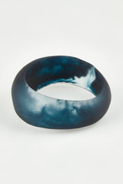A model wearing the Resin Stacking Cuff Bangle in colour Navy (Blue), from the front, showing the whole outfit