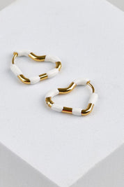 Model Genericm wearing size sample of the Hannah Heart Hoop Earring - White in colour White, in a cropped view
