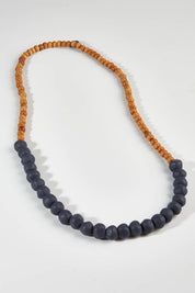 A model wearing size OneSize of the Mini Wood & Rock Necklace in colour Navy (Blue), from the front, showing the whole outfit