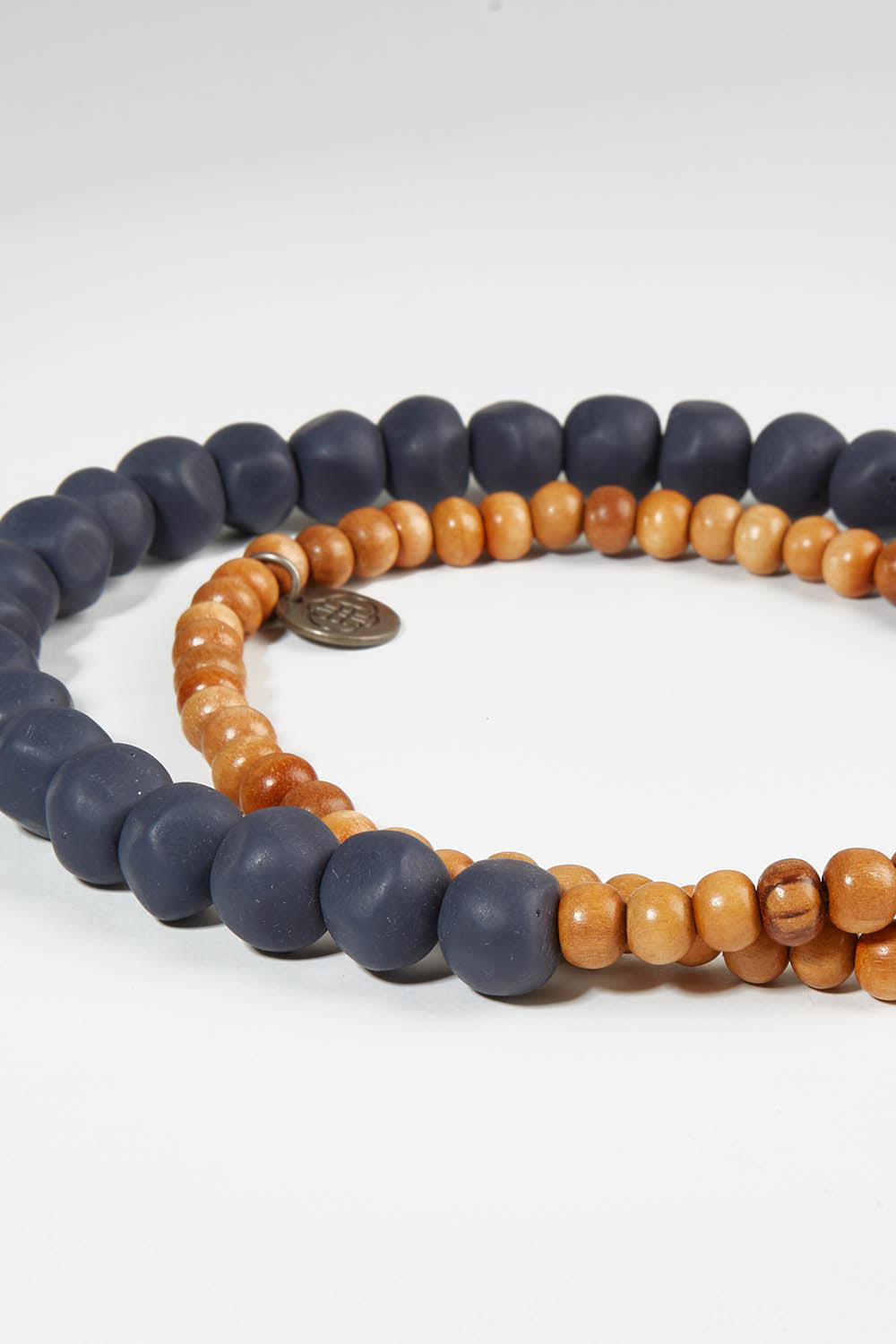 A model wearing size OneSize of the Mini Wood & Rock Necklace in colour Navy (Blue), from the front, showing the whole outfit