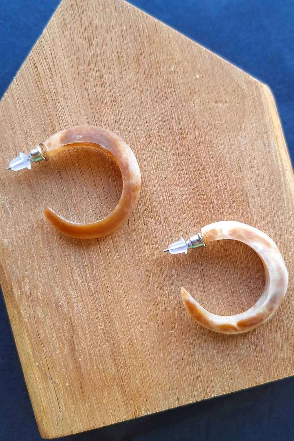 A model wearing the Point Finish Resin Hoop Earring in colour Horn, from the front, showing the whole outfit