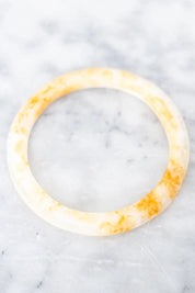 A model wearing the Point Resin Stacking Bangle in colour Horn, from the front, showing the whole outfit