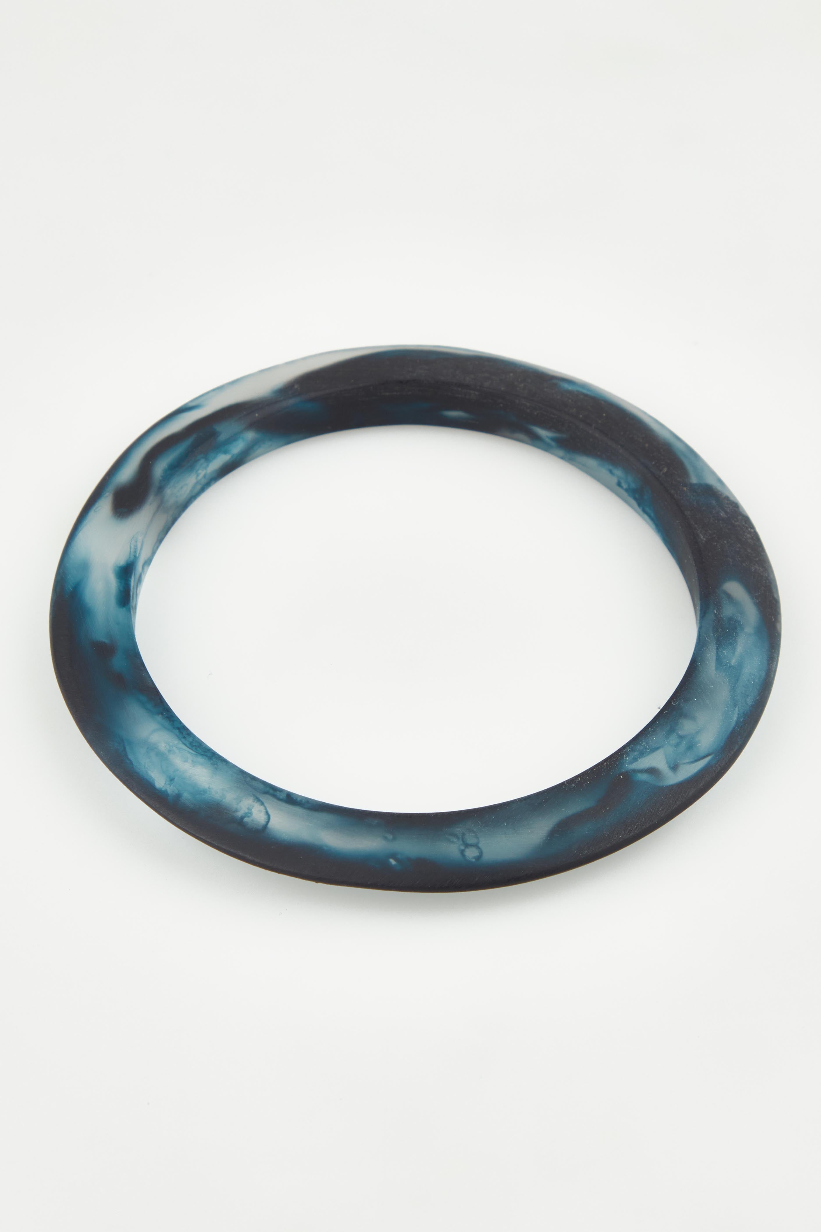 A model wearing the Point Resin Stacking Bangle in colour Navy (Blue), from the front, showing the whole outfit