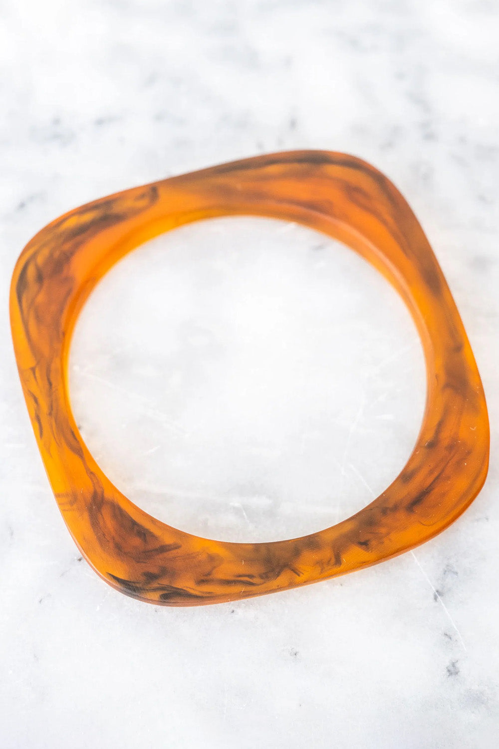 A model wearing the Square Resin Stacking Bangle in colour Tortoise, from the front, showing the whole outfit