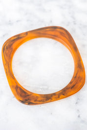 A model wearing the Square Resin Stacking Bangle in colour Tortoise, from the front, showing the whole outfit