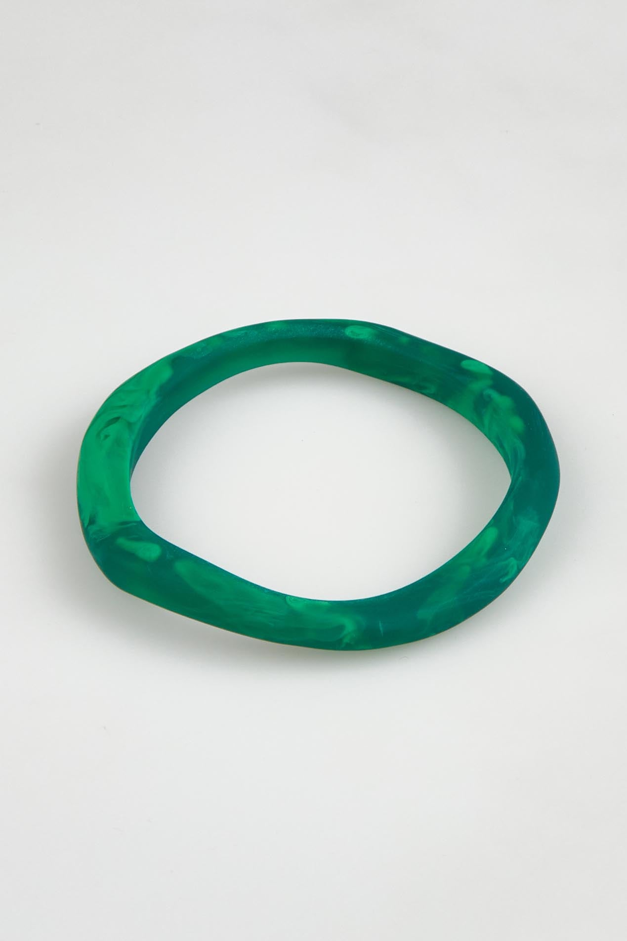 A model wearing the Wave Resin Stacking Bangle in colour Green (Green), from the front, showing the whole outfit