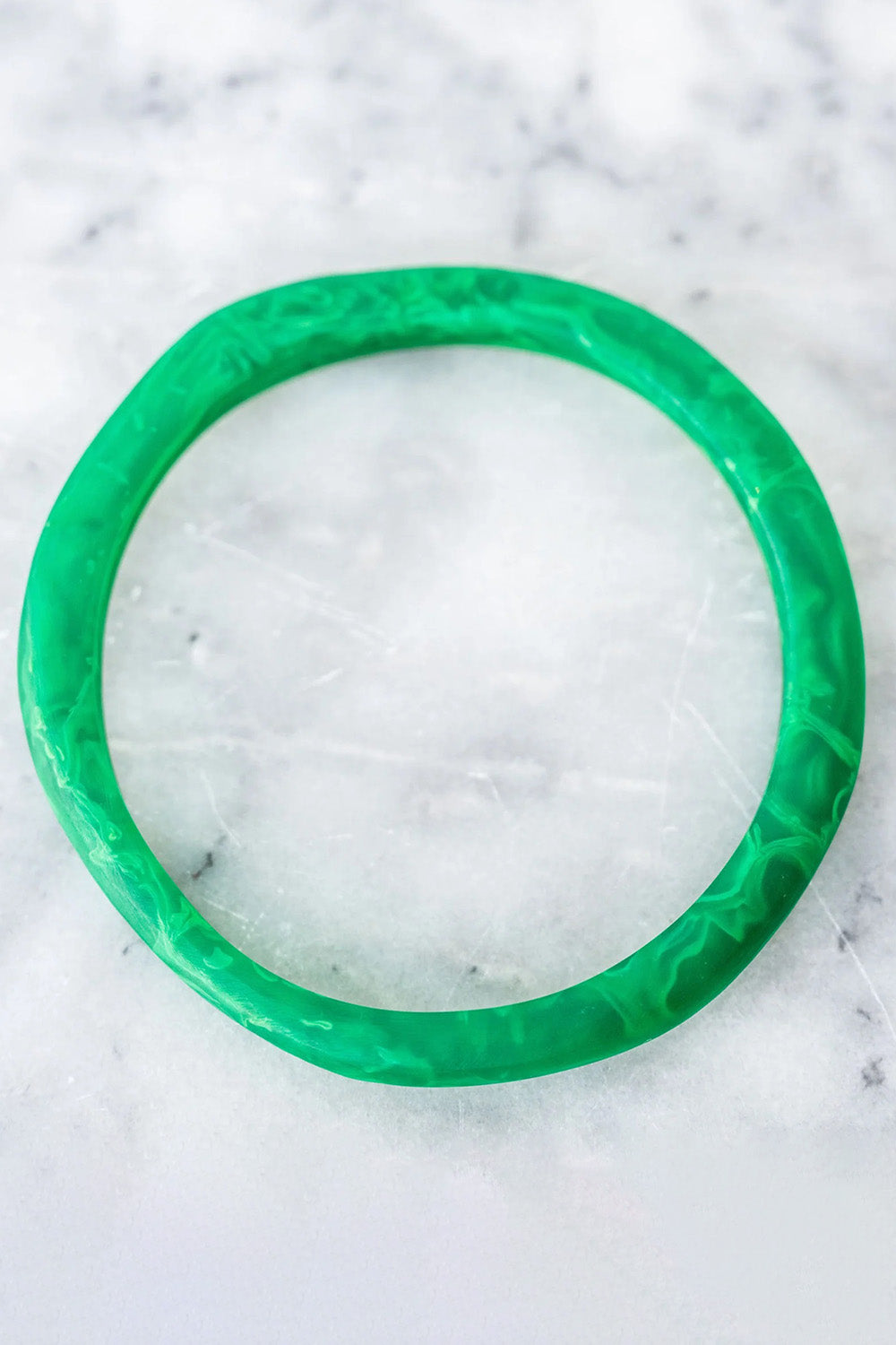 A model wearing the Wave Resin Stacking Bangle in colour Green (Green), from the front, showing the whole outfit