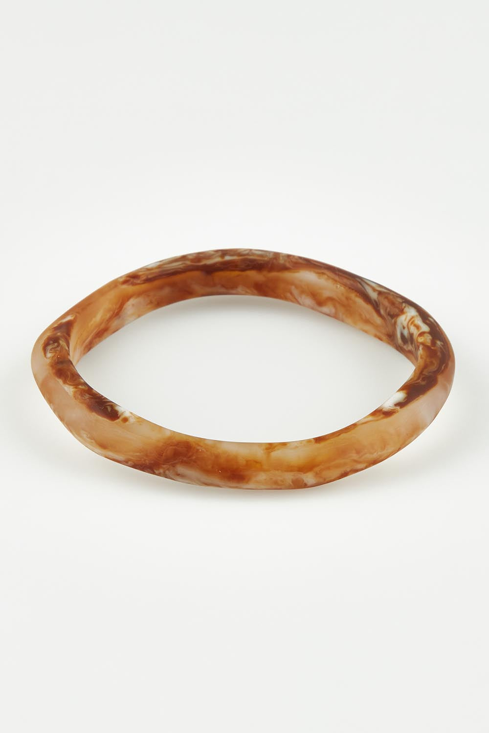 A model wearing the Wave Resin Stacking Bangle in colour Horn, from the front, showing the whole outfit
