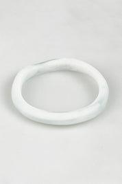 A model wearing the Wave Resin Stacking Bangle in colour White (White), from the front, showing the whole outfit