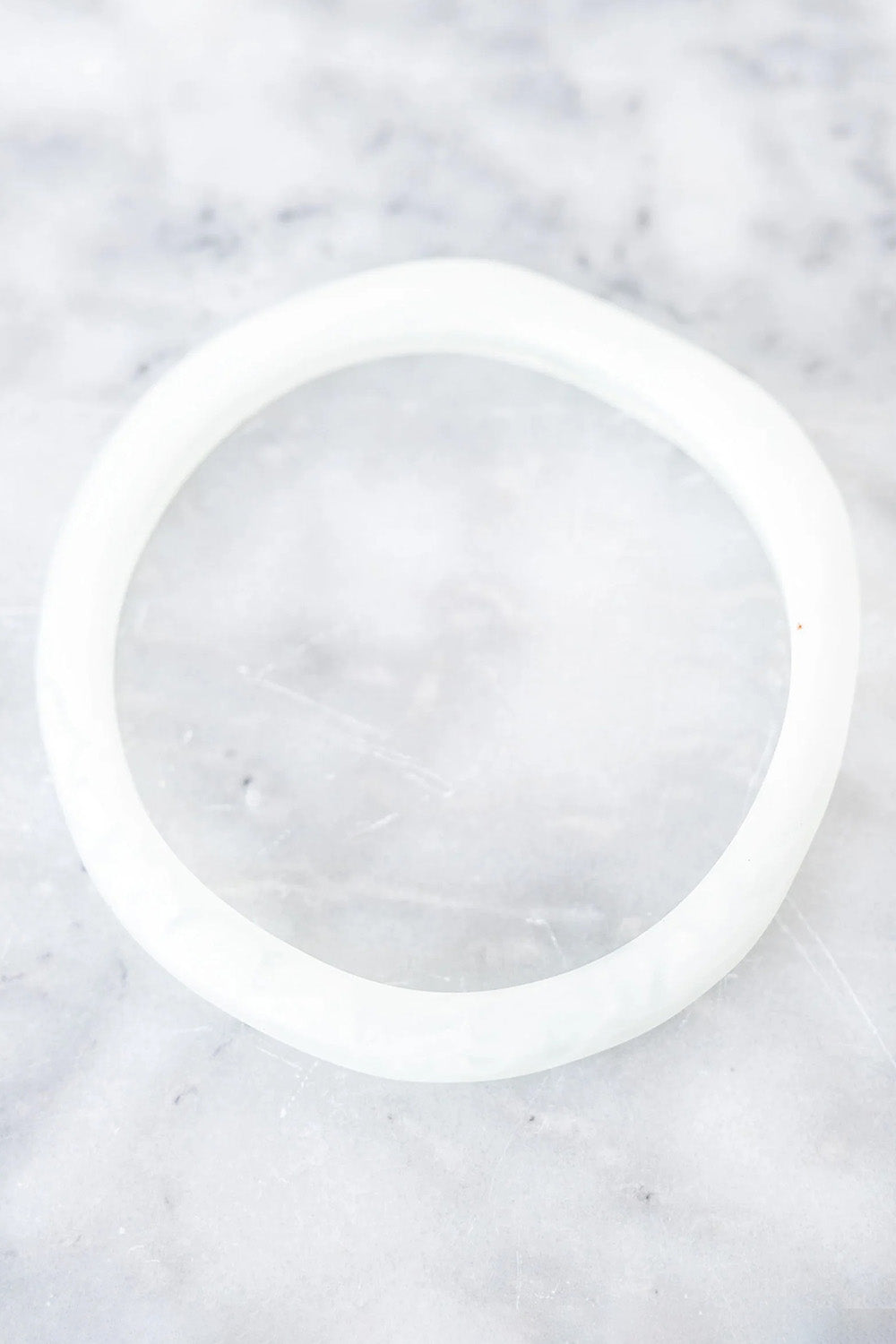 A model wearing the Wave Resin Stacking Bangle in colour White (White), from the front, showing the whole outfit