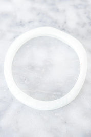 A model wearing the Wave Resin Stacking Bangle in colour White (White), from the front, showing the whole outfit