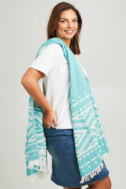 Model Monique wearing size OneSize of the Hammamas Aztec Cotton Towel in colour Emerald (Green), from the front, cropped image