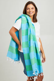 Model Monique wearing size OneSize of the Hammamas Bold Cotton Towel in colour Appleaqua (Green), from the front, cropped image