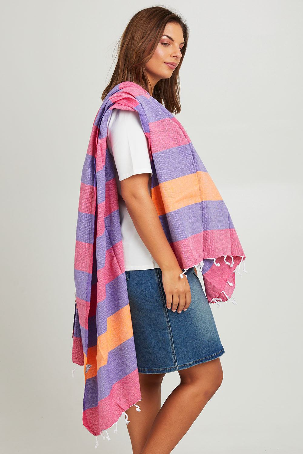 Model Monique wearing size OneSize of the Hammamas Clash Towel in colour Candyiris (Pink), from the front, cropped image