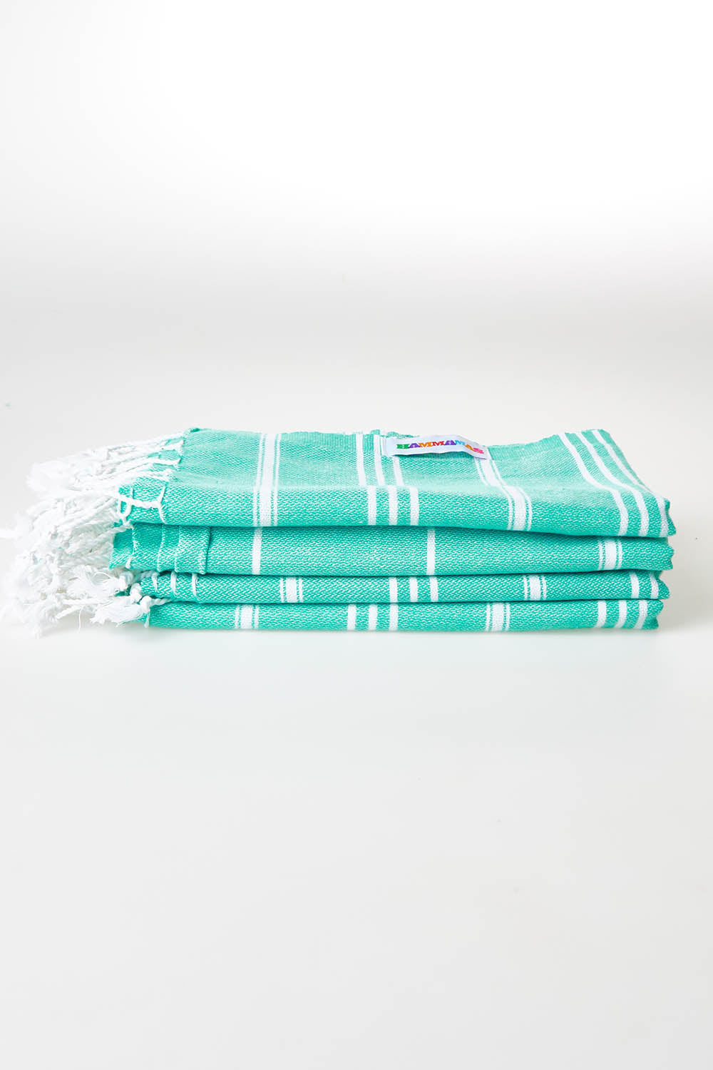 A model wearing size OneSize of the Hammamas Cotton Bubs Towel in colour Spearmint (Green), from the front, showing the whole outfit