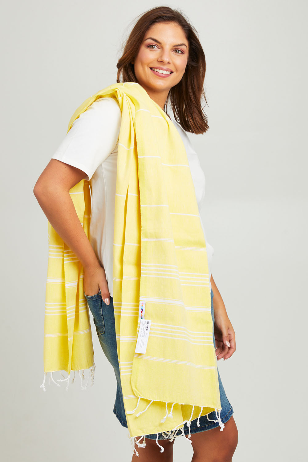 Model Monique wearing size OneSize of the Hammamas Original Cotton Towel in colour Daisy, from the front, cropped image