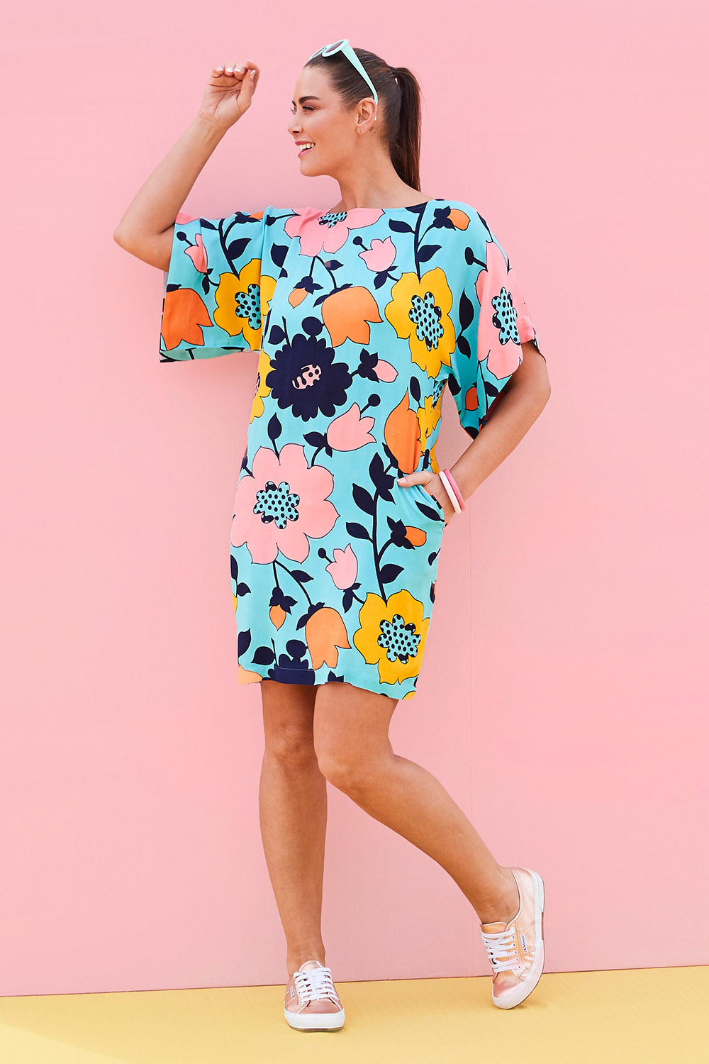 Model Abby wearing size 14 of the Bell Sleeve Tunic Dress in colour Flower (Blue), from the front, showing the whole outfit