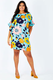 Model Shanaya wearing size 14 of the Bell Sleeve Tunic Dress in colour Flower (Blue), from the front, showing the whole outfit