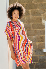 Model Olivia wearing size 10 of the Bell Sleeve Tunic Dress in colour Reflection (Pink), from the front, showing the whole outfit