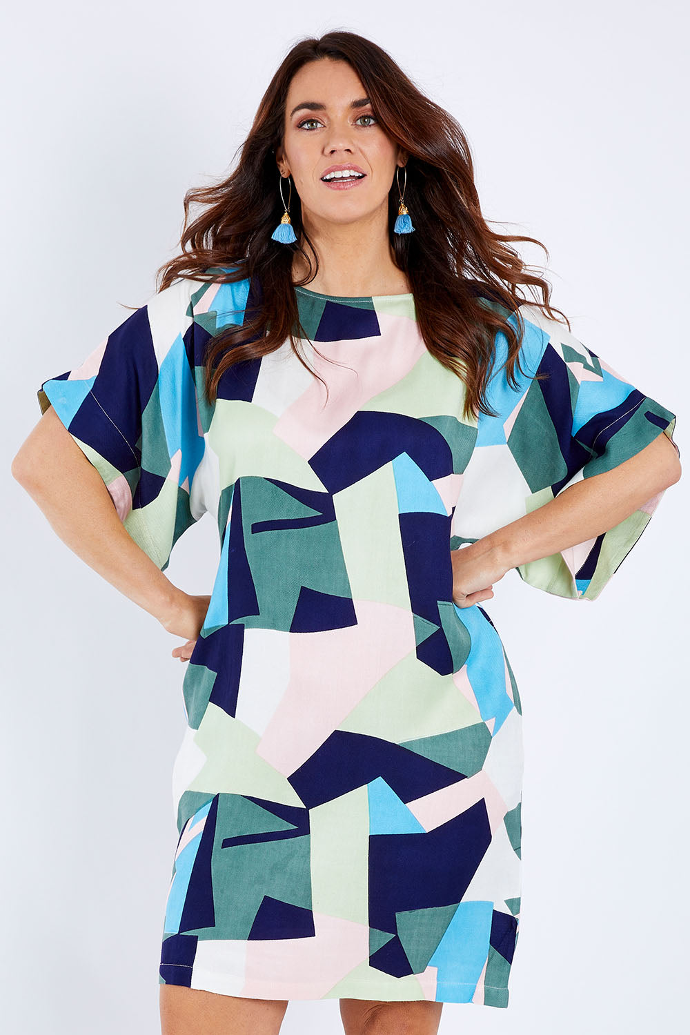 Model Laura wearing size 14 of the Bell Sleeve Tunic Dress in colour Geo (Blue), from the front, cropped image