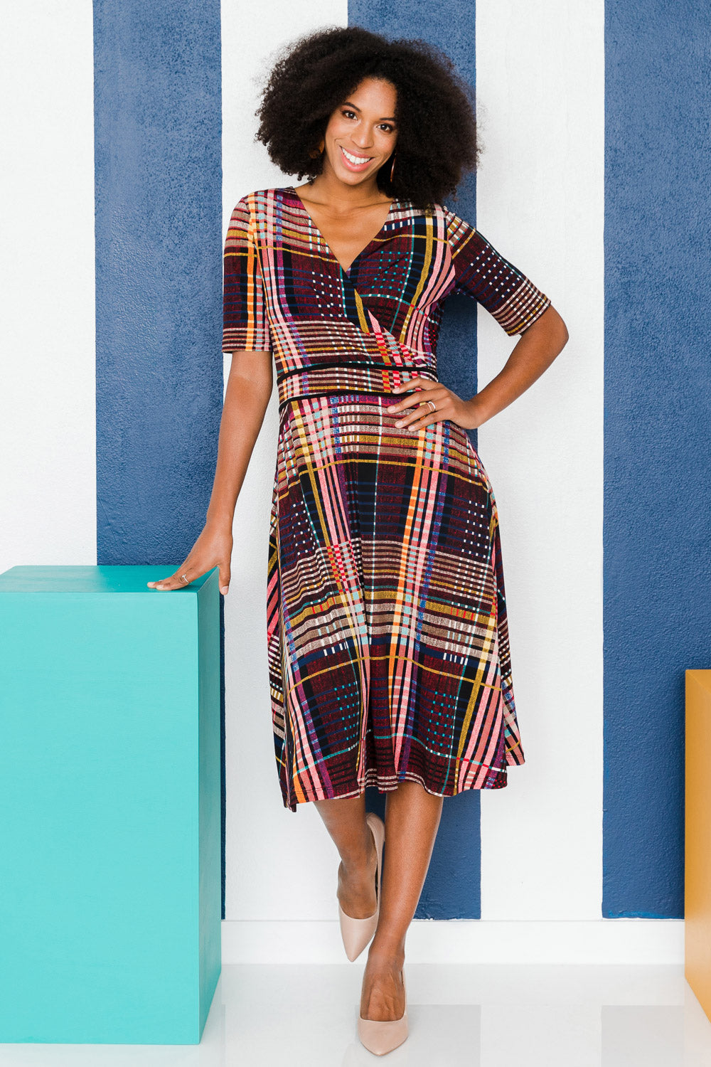 Model Schanez wearing size 10 of the Printed Short Sleeve Faux Wrap Dress in colour Checked (Black), from the front, showing the whole outfit