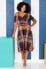 Model Schanez wearing size 10 of the Printed Short Sleeve Faux Wrap Dress in colour Checked (Black), from the front, showing the whole outfit