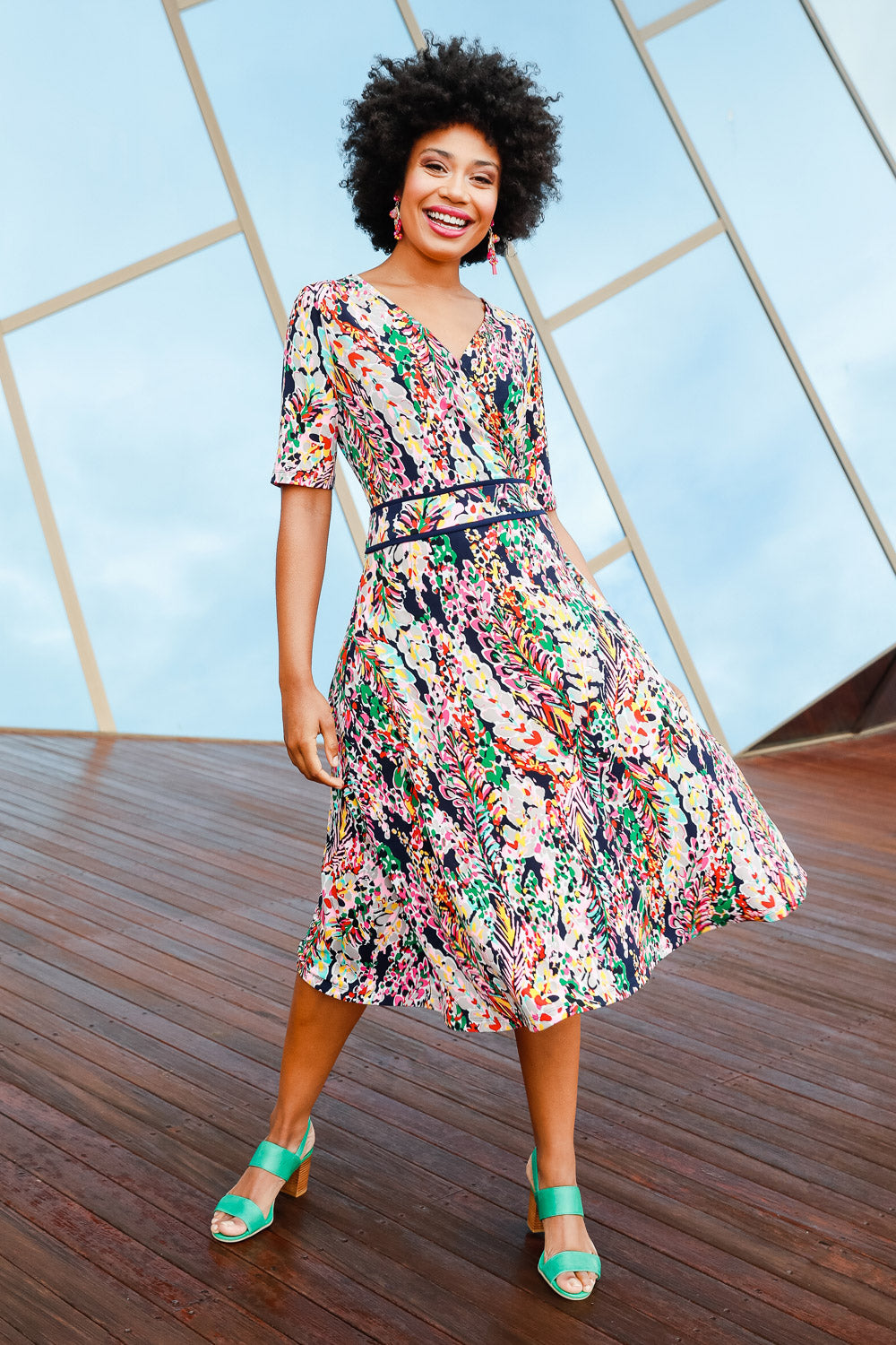 Model Olivia wearing size 10 of the Printed Short Sleeve Faux Wrap Dress in colour Colourful (Blue), from the front, showing the whole outfit