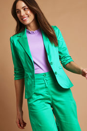 Model Madeline wearing size 10 of the Buttoned Blazer in colour Emerald (Green), from the front, showing the whole outfit